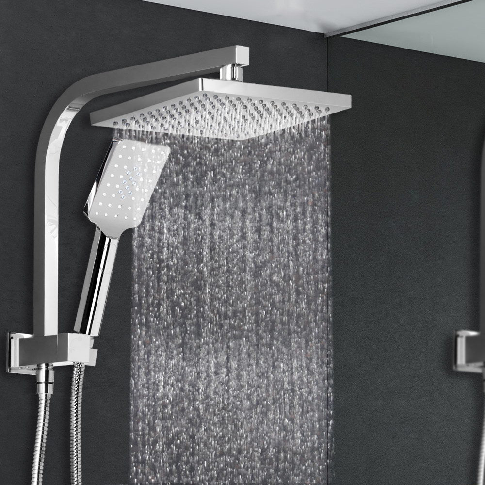 A big 8 inch square silver showerhead and handheld shower in a black tile and glass walled shower stall.