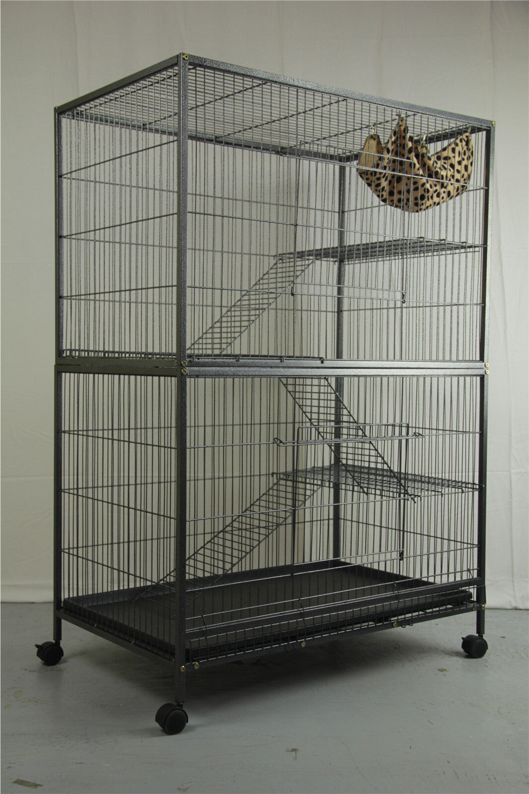 A very big Bird or hamster and rat cage with 3 levels on castor wheels with a little cheetah print nest in the top corner.